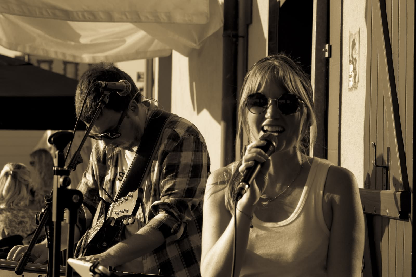Symbiose en concert en 2026, prestation live guitare et voix sous une terrasse couverte