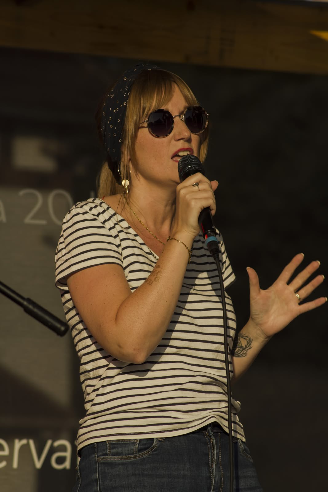 Symbiose en concert en 2026, Angélique chante au micro lors d'une prestation live