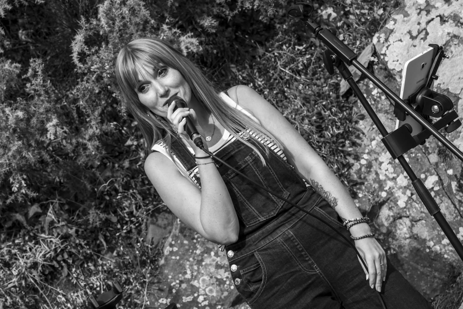 Symbiose en concert en 2026, Angélique chante en plein air sur une photographie artistique en noir et blanc