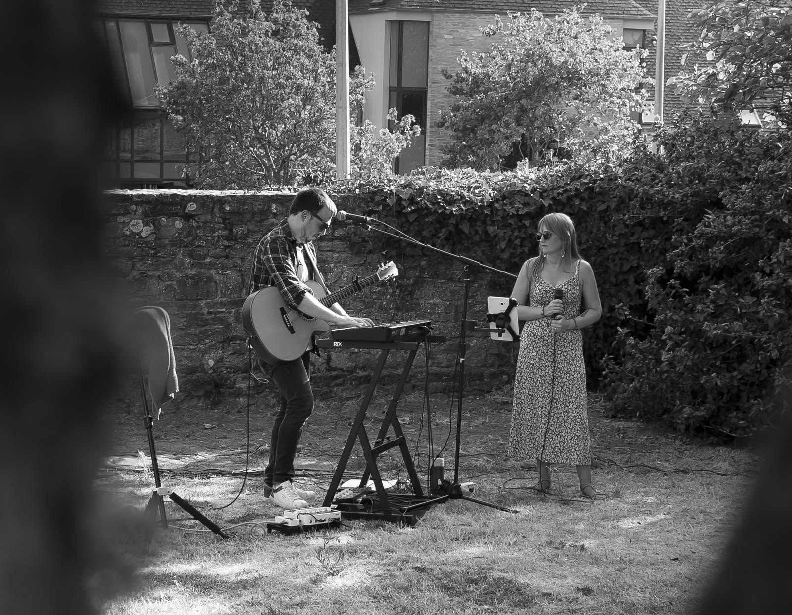 Symbiose en concert en 2026, duo guitare et voix en plein air photographié en noir et blanc