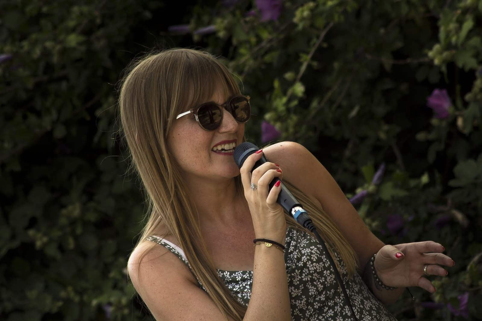 Symbiose en concert en 2026, portrait d'Angélique chantant avec ses lunettes de soleil